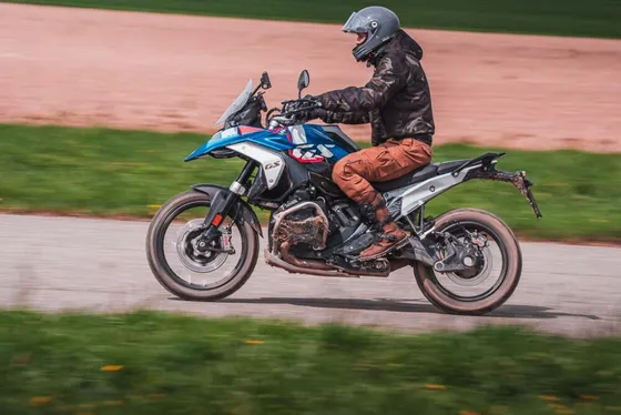 Zablácená BMW R 1250 GS v rychlé jízdě po silnici