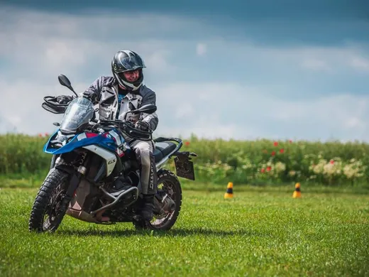 Nácvik pomalé zatáčky na BMW R 1250 GS na kvetoucí louce