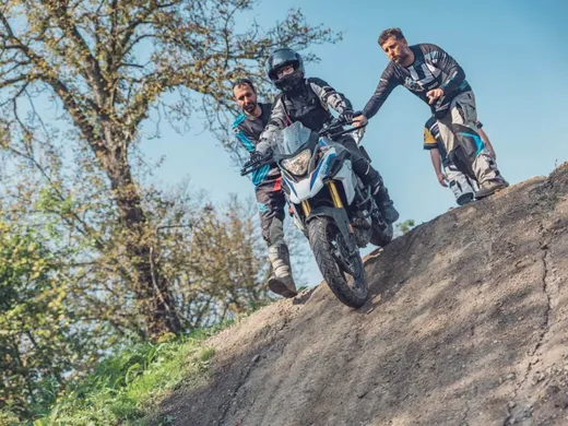 Lektoři jistí studenta při sjezdu strmého svahu na BMW F 850 GS