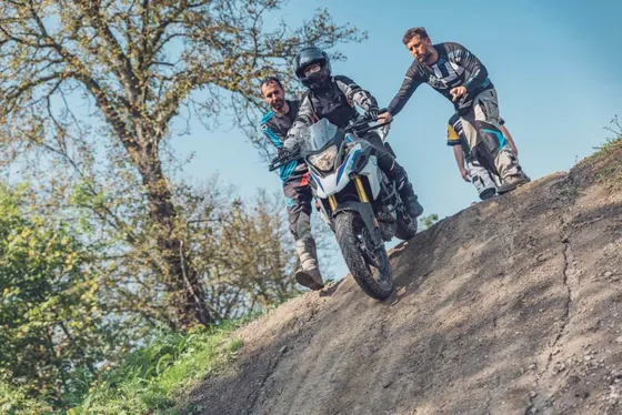Lektoři jistí studenta při sjezdu strmého svahu na BMW F 850 GS