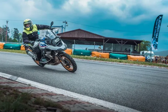 Jezdec naklání BMW R 1250 GS do zatáčky závodního okruhu